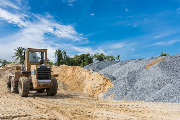 Pile of sand and stone with shoval tractor