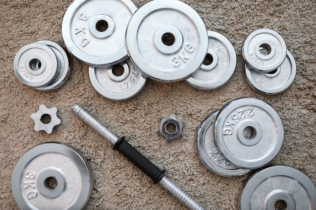 Pile of shiny chrome dumbbells disks lying around grip