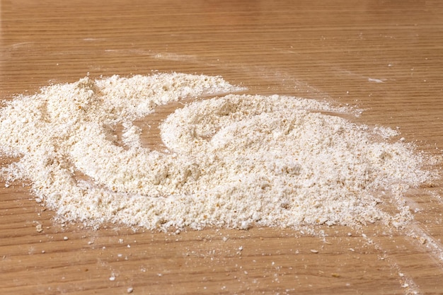 Photo a pile of sifted flour on a table sprinkled flour on a table