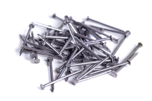 Pile of small grey metal nails isolated on white background Closeup view