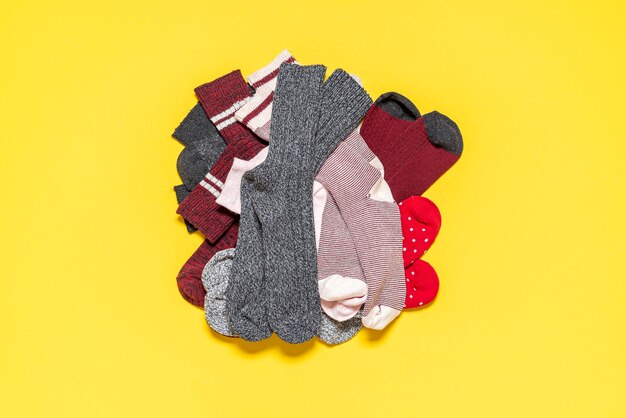 Pile of socks on a yellow background Top view with many socks