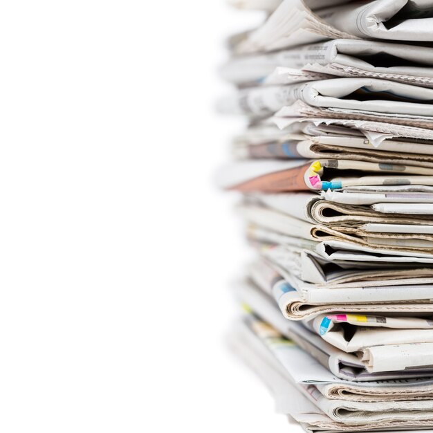Pile of stacked generic folded newspapers on white background