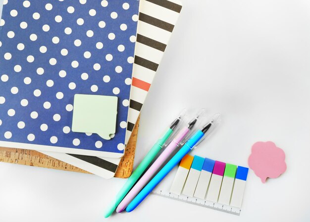 A pile of stylish notebooks and stationary isolated on white background