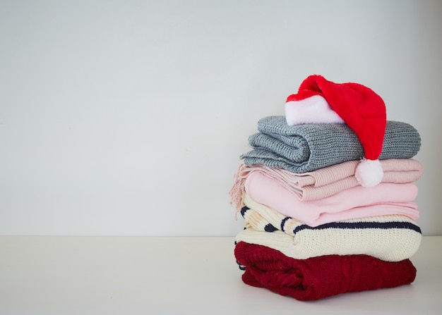 Pile sweater with Santa hat on table