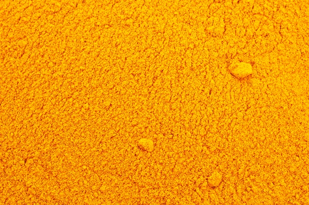 Pile of turmeric powder background top view yellow turmeric powder texture background