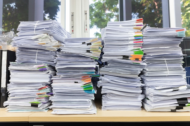 Photo pile of unfinished documents on office desk