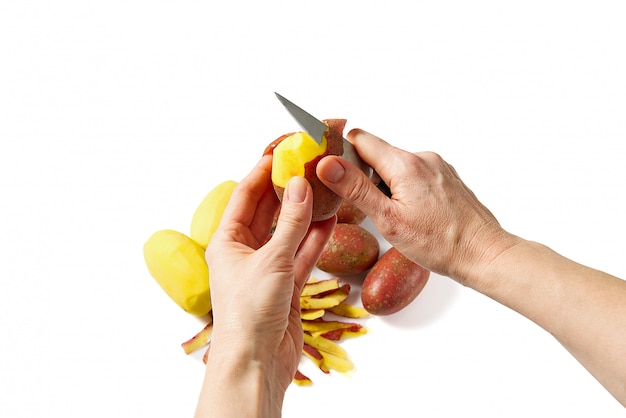 Un mucchio di patate non sbucciate e peeling di patate rosse