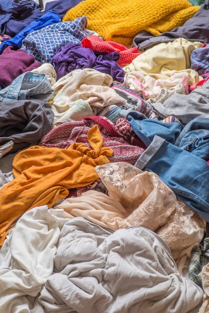 Pile of used clothes on a light background Second hand for recycling