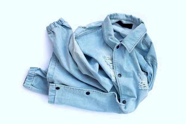 Pile of used jeans shirt on white surface