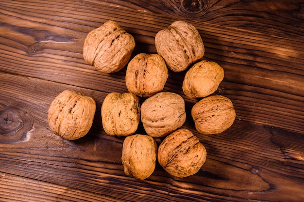 Pile of walnuts on rustic wooden table. Top view