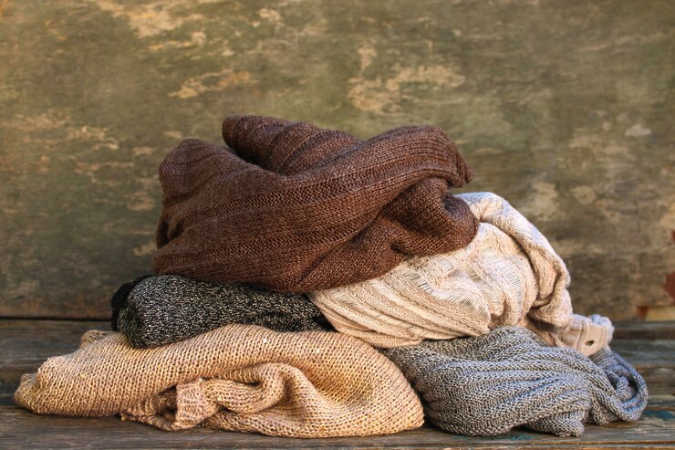Photo pile of warm clothes on wooden floor