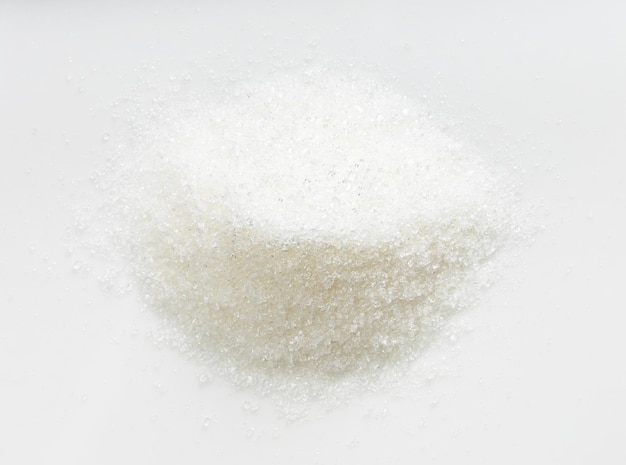 Pile of white refined beet sugar close up on gray