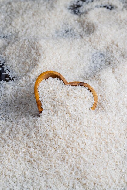 A pile of white rice on the kitchen table in a wooden plate