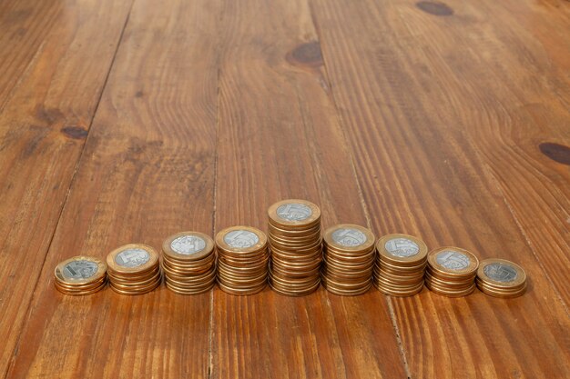 Photo a pile with a lot of real brazilian money coins stacked as an histogram on a wood table