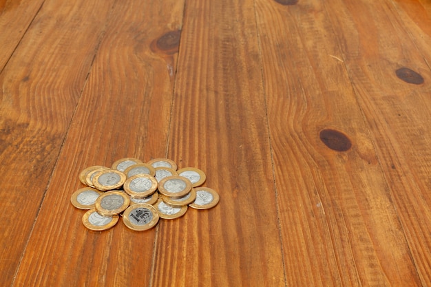 Photo a pile with a lot of real brazilian money coins on a wood table