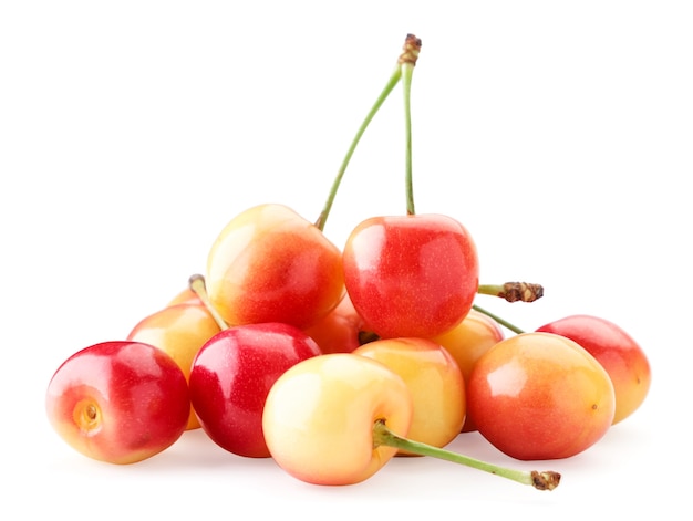 A pile of yellow-red sweet cherry close-up on white