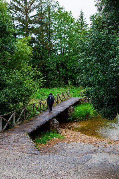 Pilgrim walking on the wooden bridge over the river along the Camino de Santiago