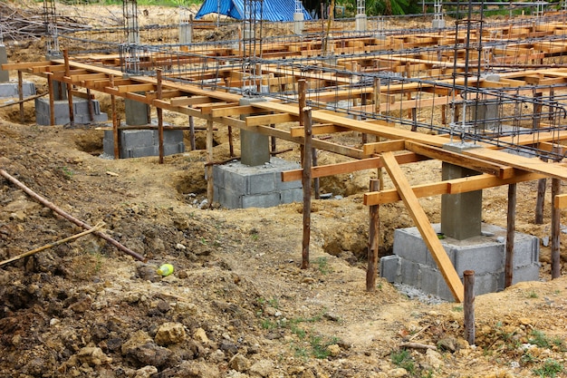 建設現場の建物の1階にセメントを作るための鉄骨構造で補強されたセメントの杭杭。