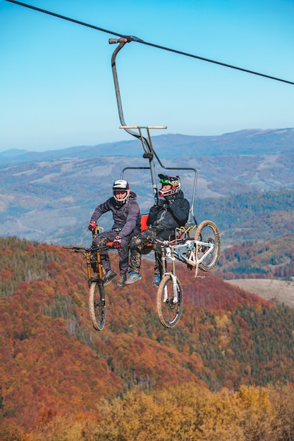 Pilipets, Oekraïne - 10 oktober 2021: fietsers met mountainbikes op stoeltjeslift herfstseizoen