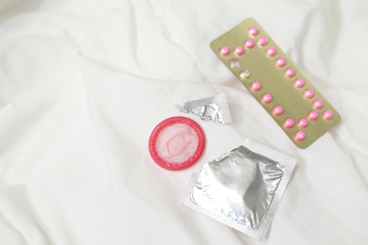 Photo pill contraceptive and condom on the bed
