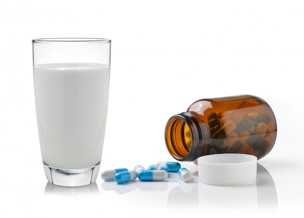 Pill and glass of milk isolated on white background