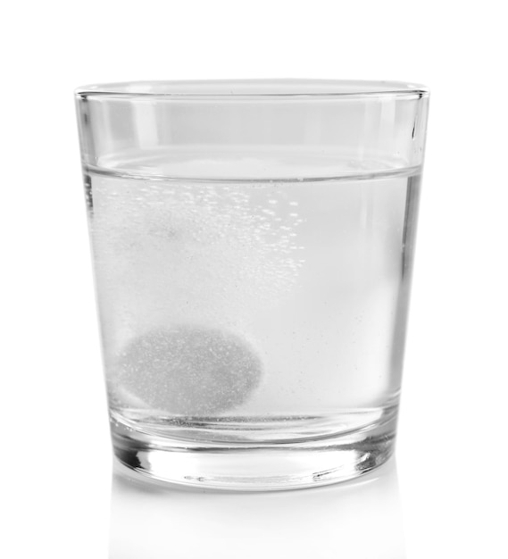 Pill in glass of water on light background