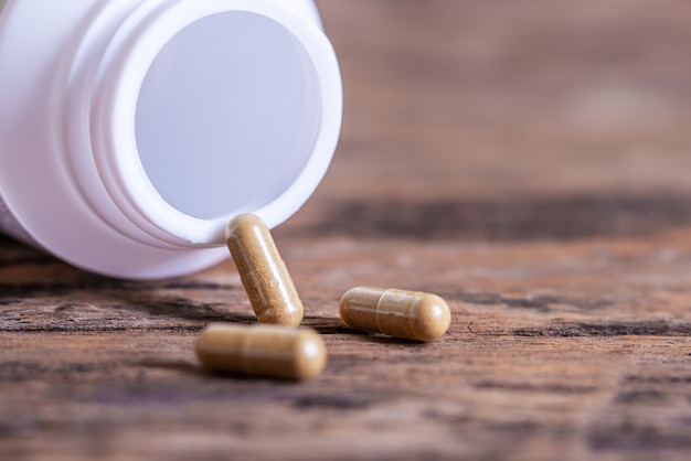 Pill spilling out of a bottle blurred background, Medicine capsule for health, Vitamin spilling out from bottle, Macro