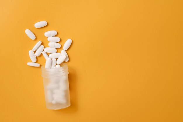 Photo pill tablets on a yellow surface