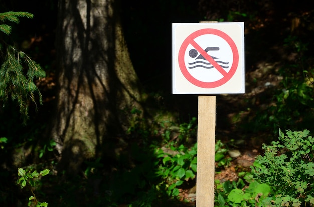 Photo a pillar with a sign denoting a ban on swimming.