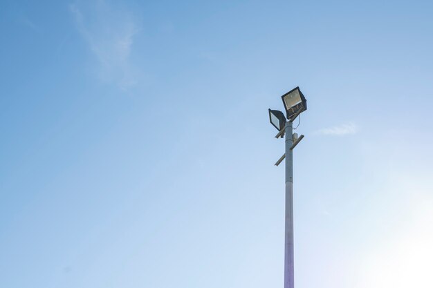 Pillar with two projectors against a blue sky