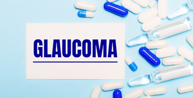 Pillen, ampullen en een witte kaart met de tekst glaucoma op een lichtblauwe ondergrond