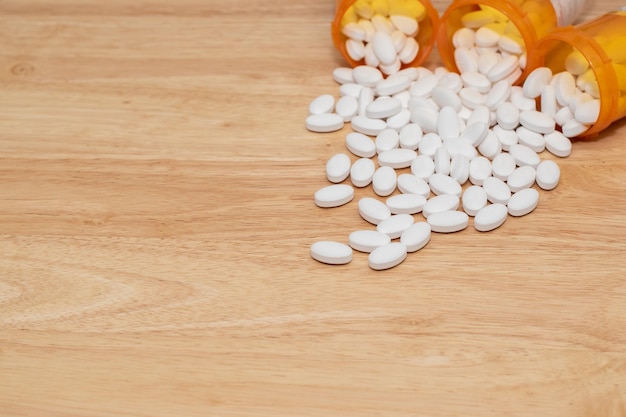 Pillen die uit de capsule van het medicijn komen met kopieerruimte in de tafel