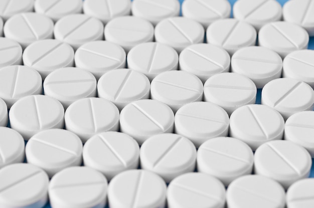 Pillen tabletten capsules close-up. Op een blauwe achtergrond, een potje geneeskunde.