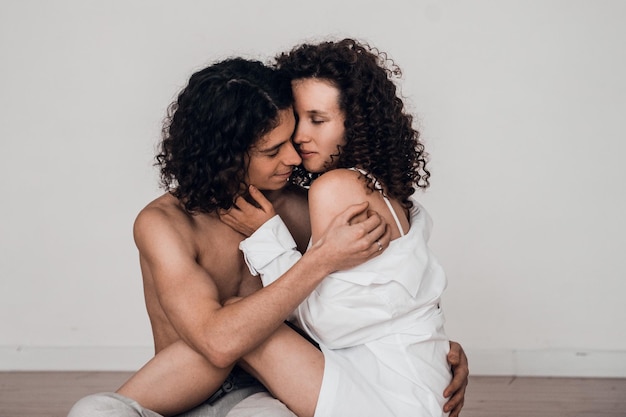 pillow fight - loving couple man and woman playing together at home, close relations concept