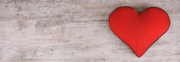 Foto cuscino cuore rosso su fondo di legno bianco vecchio