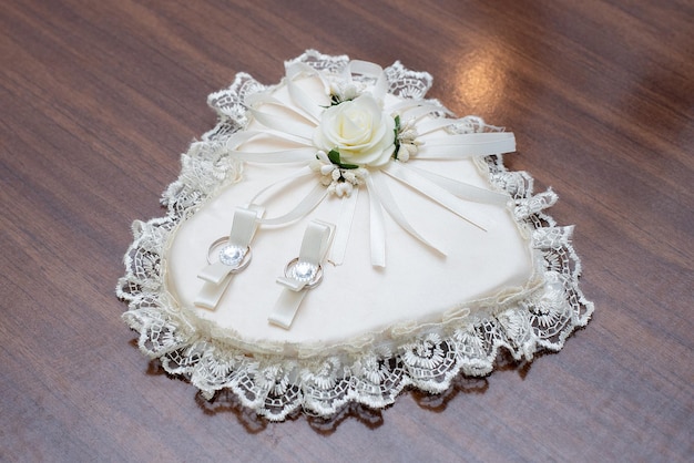 Pillow for rings in the shape of a heart on the table marriage ceremony