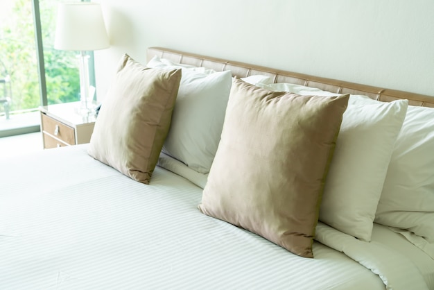 Photo pillows on bed in bedroom interior