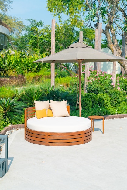 pillows on outdoor patio chair with umbrella in garden