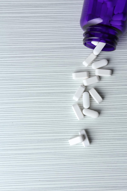 Pills in bottle on white table