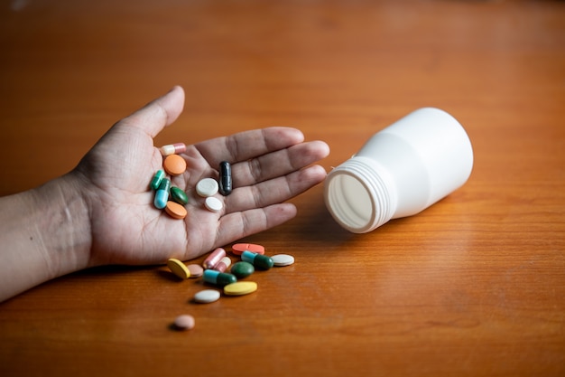 Pills and capsule on hand of women