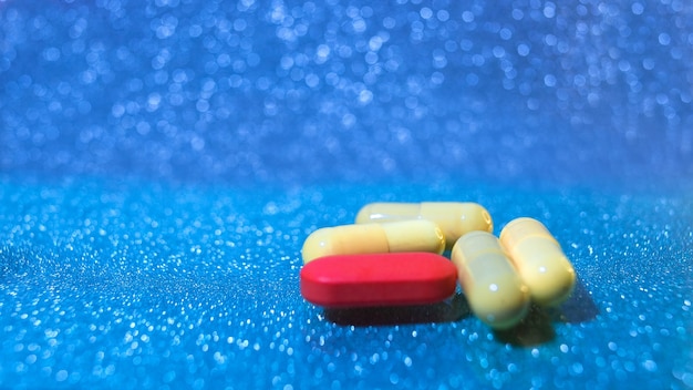 Pills or capsules on blue background with copy space. Drug prescription for treatment medication.