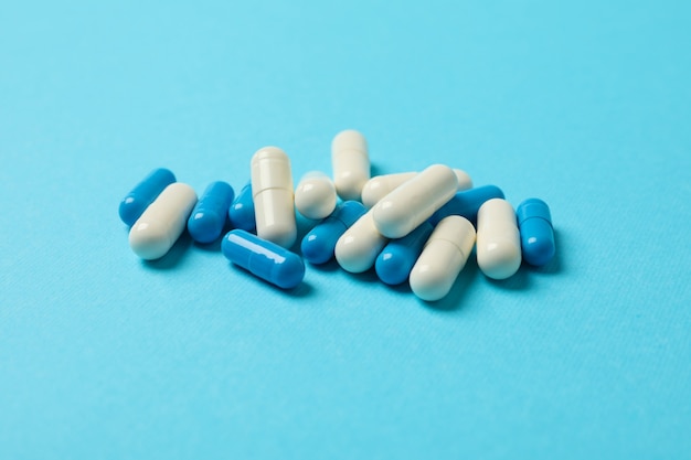 Pills capsules on blue, space for text