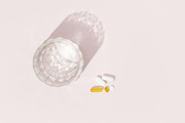 Pills capsules and glass of water Preparations for the treatment of colds vitamins wellness complex