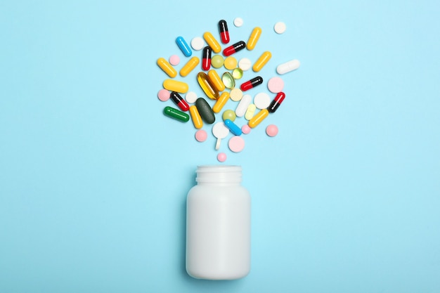 Pills on a colored background top view medicine treatment illness