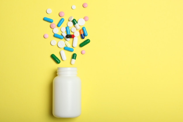 Pills on a colored background top view medicine treatment illness