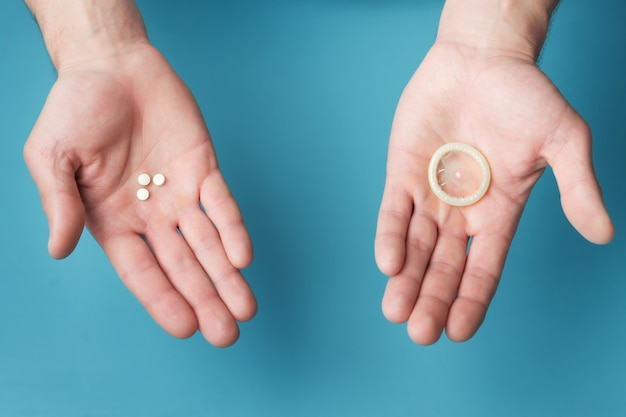  Pills and condom in hands