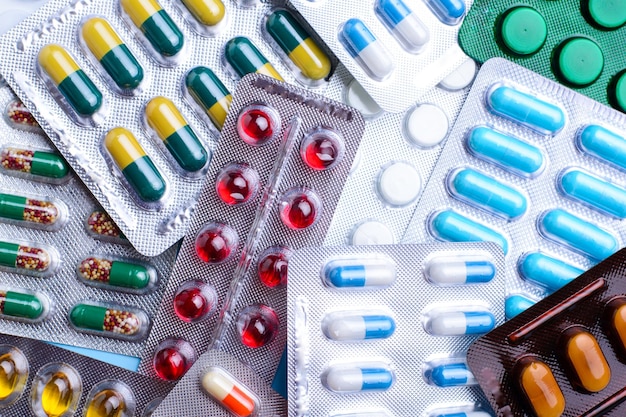 Pills of different colours lay on table