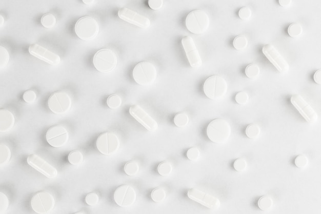 Pills flat background tablets spreaded on a white topdown view