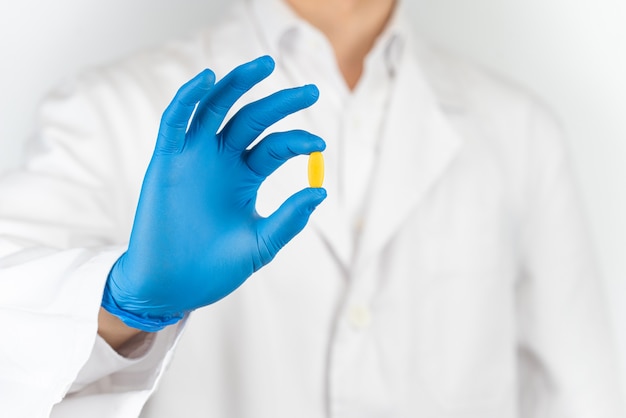 Pills in the hands of a doctor wearing gloves