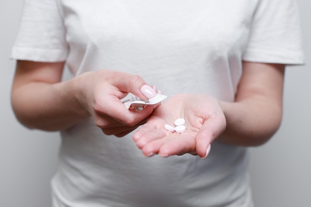 Pills in the hands of a woman treatment migraine virus